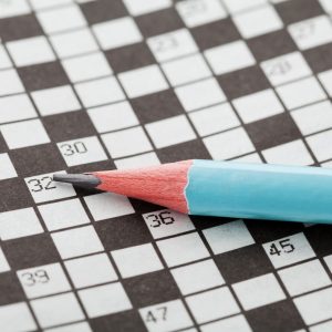 Closeup crossword puzzle and blue pencil